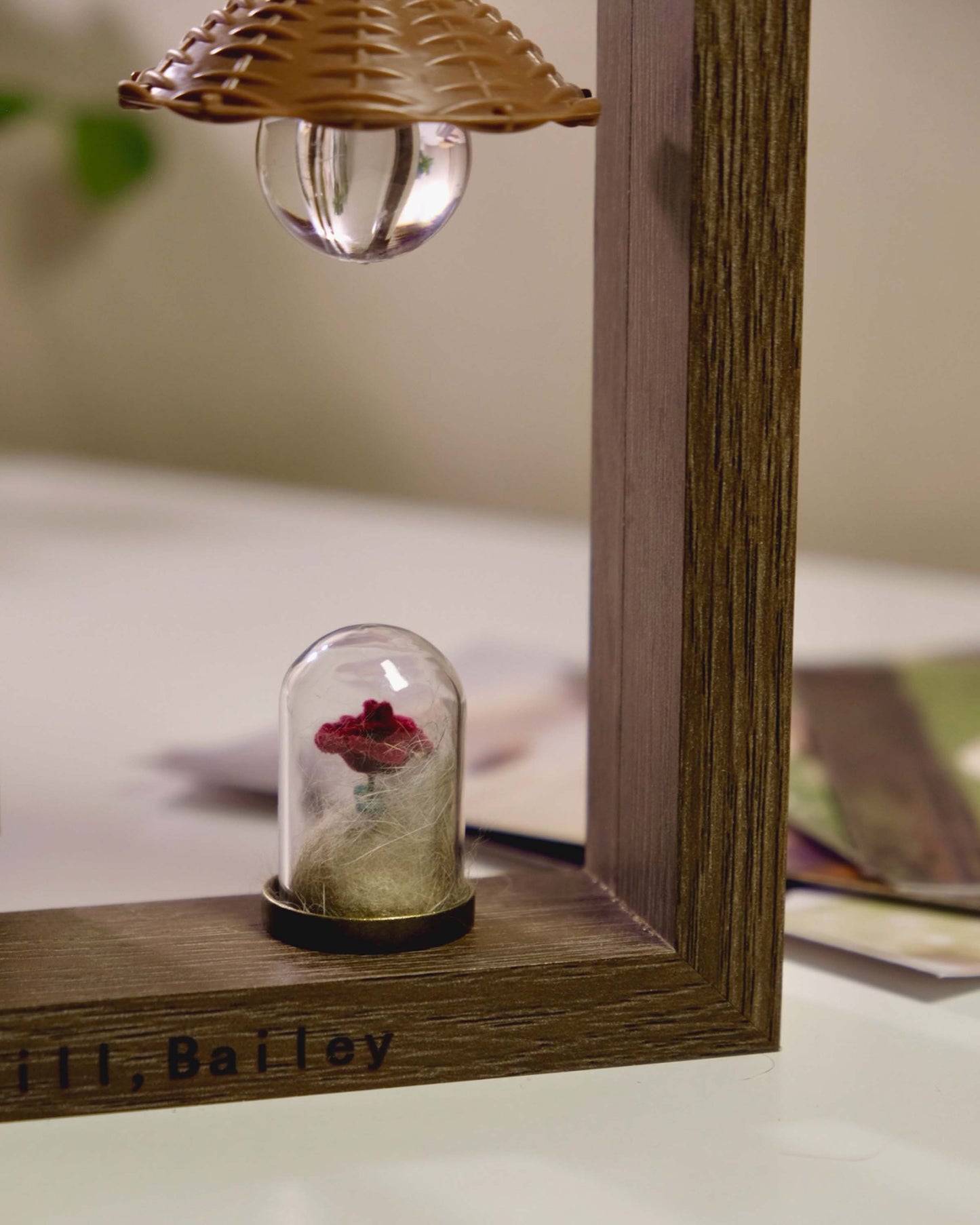 Personalized wooden pet memorial frame with a glass rose keepsake vial holding a small tuft of pet fur.