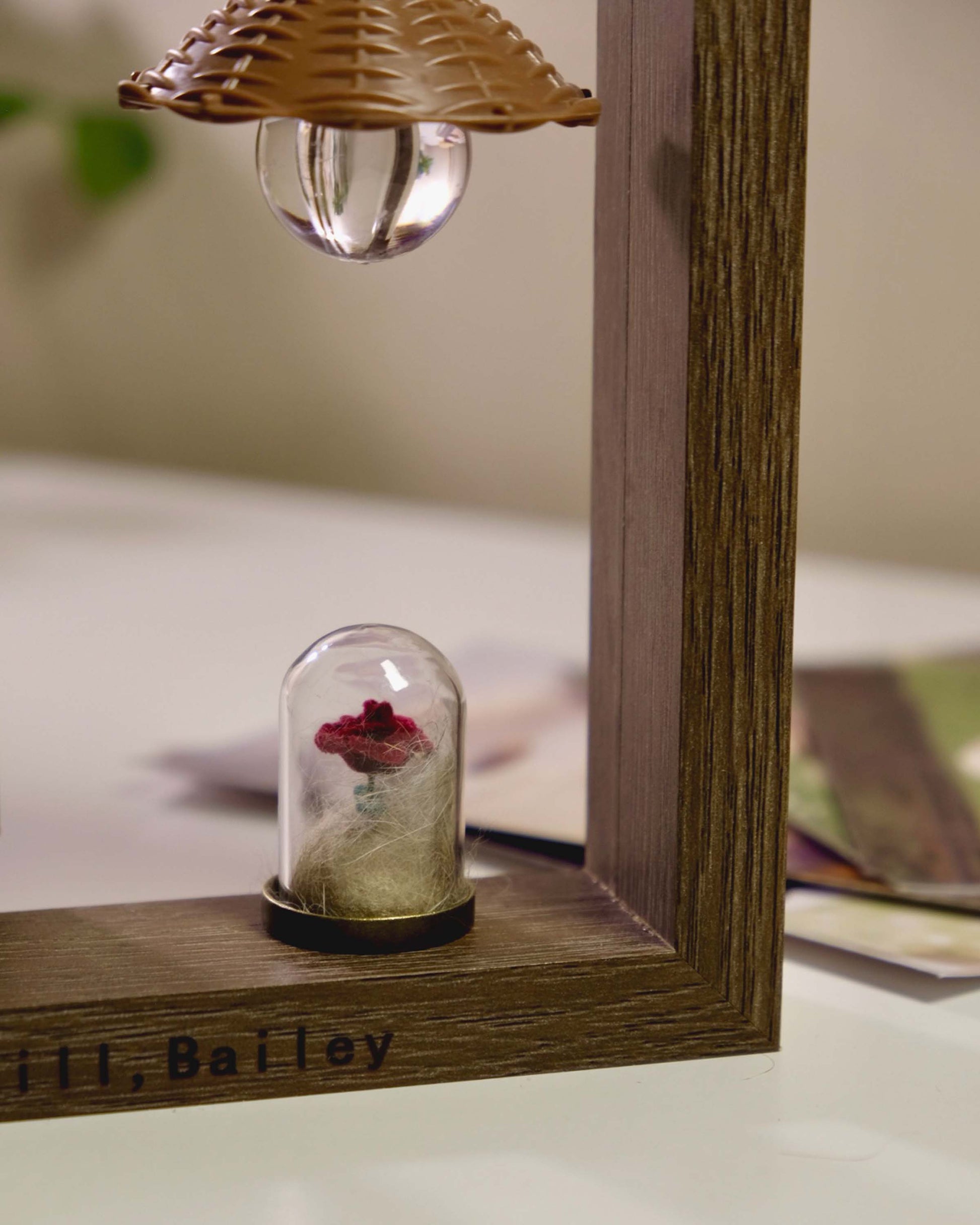 Personalized wooden pet memorial frame with a glass rose keepsake vial holding a small tuft of pet fur.
