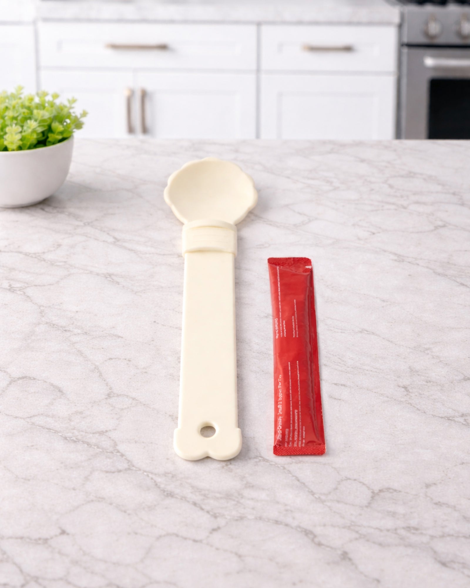 Hand holding WhiskerBloom TreatStrip Spoon while feeding a cat treat stick
