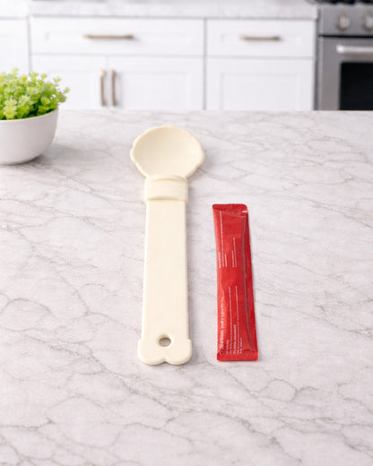 Hand holding WhiskerBloom TreatStrip Spoon while feeding a cat treat stick